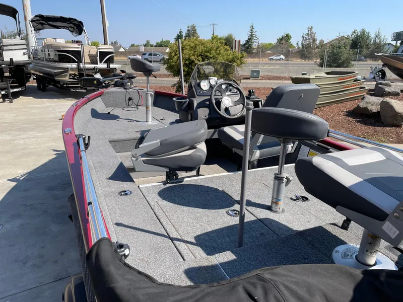 Slide: The Image of 2022 Tracker Super Guide V-16 SC fishing boat with seating and steering console, parked outdoors. - 4