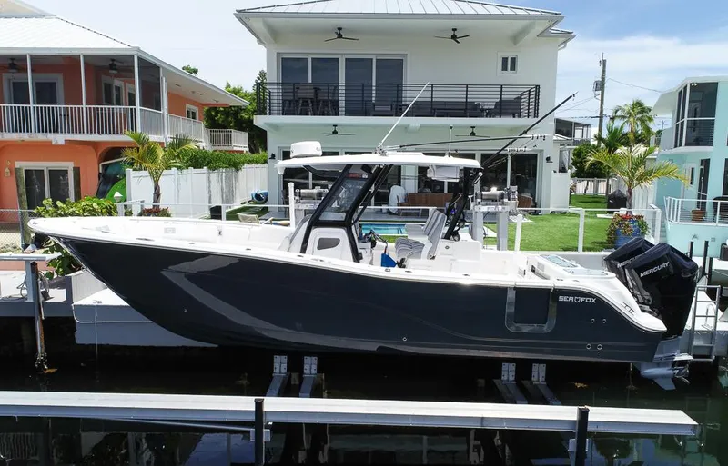 The Image of 2024 Sea Fox 328 Commander boat docked near modern waterfront homes. - 1