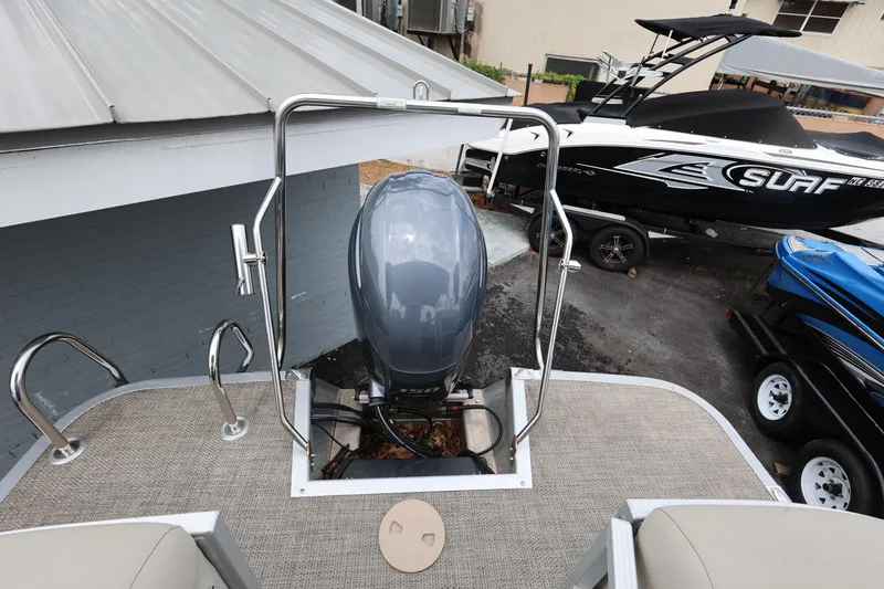 Slide: The Image of 2019 Bennington SX 22 SSXP boat with outboard motor, parked near other boats. - 14
