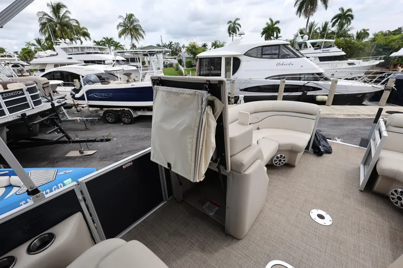 Slide: The Image of 2019 Bennington SX 22 SSXP pontoon boat interior at marina with yachts and palm trees. - 23