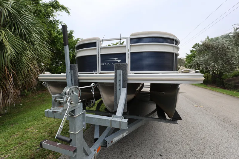 Slide: The Image of 2019 Bennington SX 22 SSXP pontoon boat on trailer, parked roadside with lush greenery. - 8