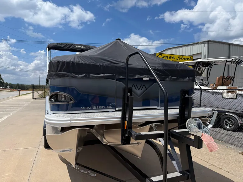 Slide: The Image of 2025 Avalon VENTURE QUAD LOUNGER boat on trailer, covered, parked outdoors. - 10