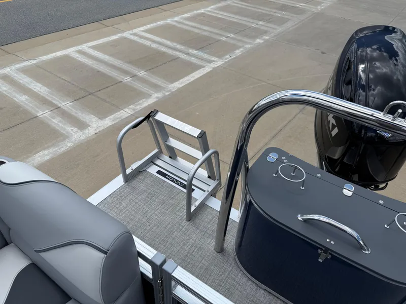 Slide: The Image of 2025 Avalon VENTURE QUAD LOUNGER boat deck with seating and motor, docked on concrete. - 22