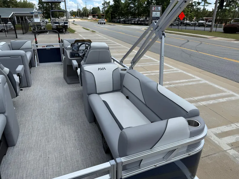 Slide: The Image of 2025 Avalon VENTURE QUAD LOUNGER pontoon boat with gray seating, parked on a street. - 27