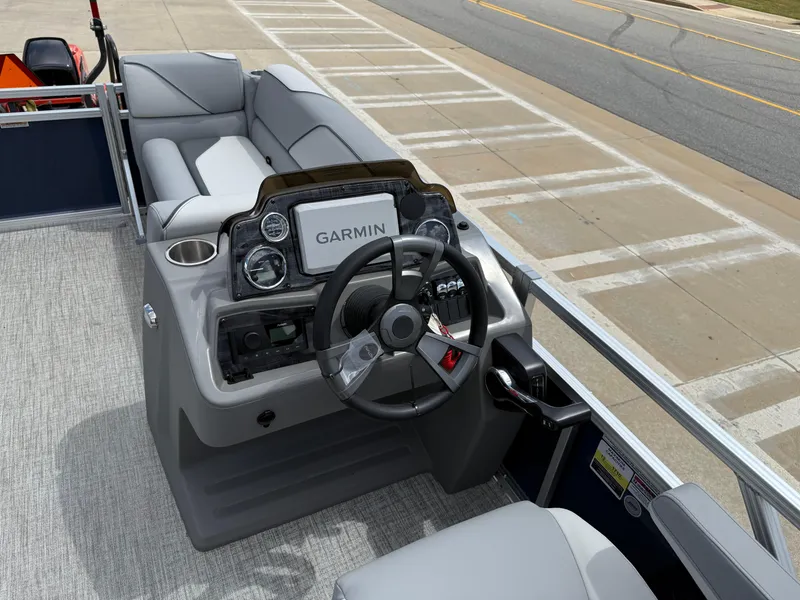 Slide: The Image of 2025 Avalon VENTURE QUAD LOUNGER boat dashboard with Garmin navigation system and plush seating. - 37