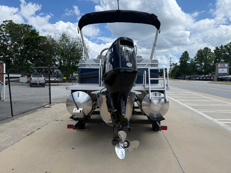 Slide: The Image of 2025 Avalon VENTURE QUAD LOUNGER pontoon boat with powerful outboard motor, parked outdoors. - 5