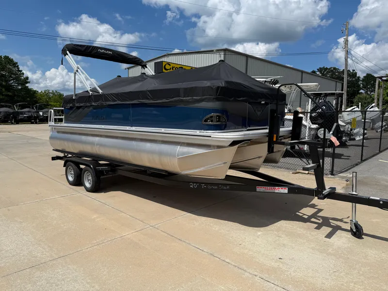Slide: The Image of 2025 Avalon Venture Quad Lounger pontoon boat on trailer, covered and parked outdoors. - 7