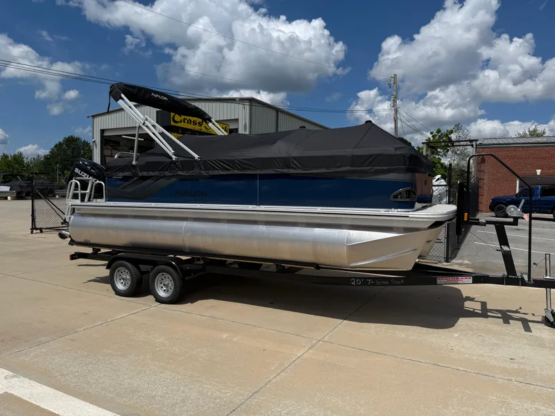 Slide: The Image of 2025 Avalon VENTURE QUAD LOUNGER pontoon boat on trailer, parked outdoors under a cloudy sky. - 8