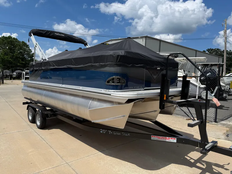 Slide: The Image of 2025 Avalon VENTURE QUAD LOUNGER pontoon boat on trailer, parked outdoors under blue sky. - 9