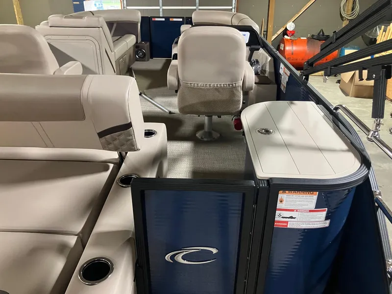 Slide: The Image of 2025 Crest 220 SLSC pontoon boat interior with beige seating and storage compartments. - 3