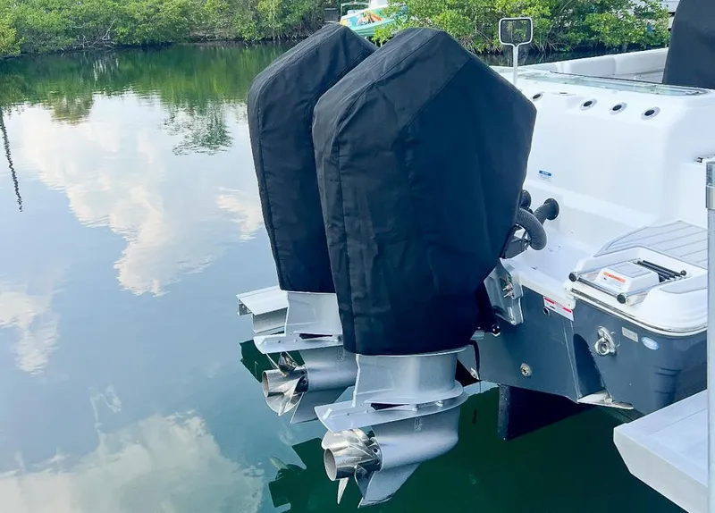Slide: The Image of 2024 Sea Fox 328 Commander boat with covered dual outboard motors on calm water. - 23
