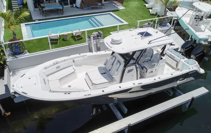 Slide: The Image of 2024 Sea Fox 328 Commander boat docked near a poolside patio. - 3