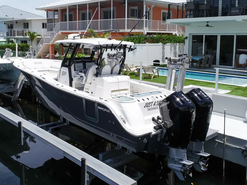Slide: The Image of 2024 Sea Fox 328 Commander boat docked near modern waterfront homes. - 7