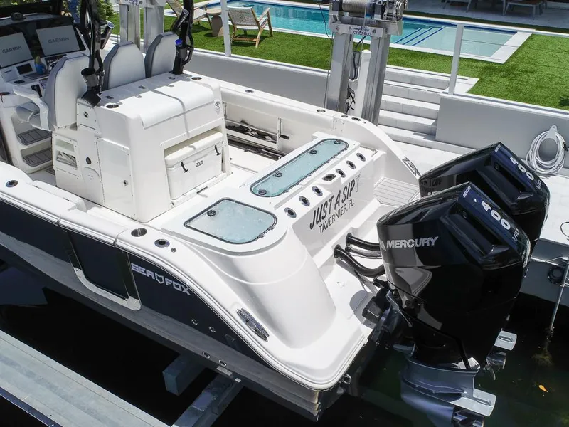 Slide: The Image of 2024 Sea Fox 328 Commander boat with dual Mercury engines docked near a pool. - 8