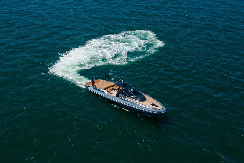 Slide: The Image of 2014 SACS Strider yacht cruising on open blue sea, leaving a swirling wake. - 1