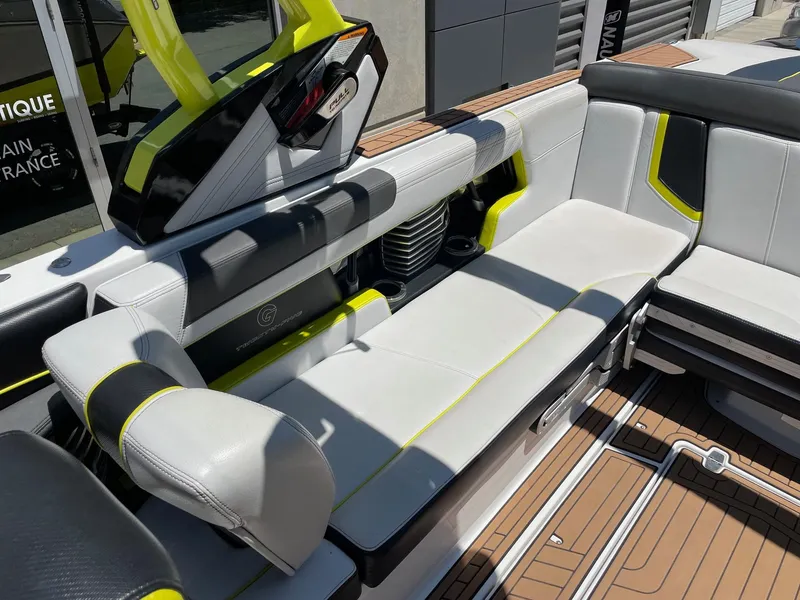 Slide: The Image of 2017 Nautique Super Air Nautique G25 interior with white and black seating, yellow accents. - 7