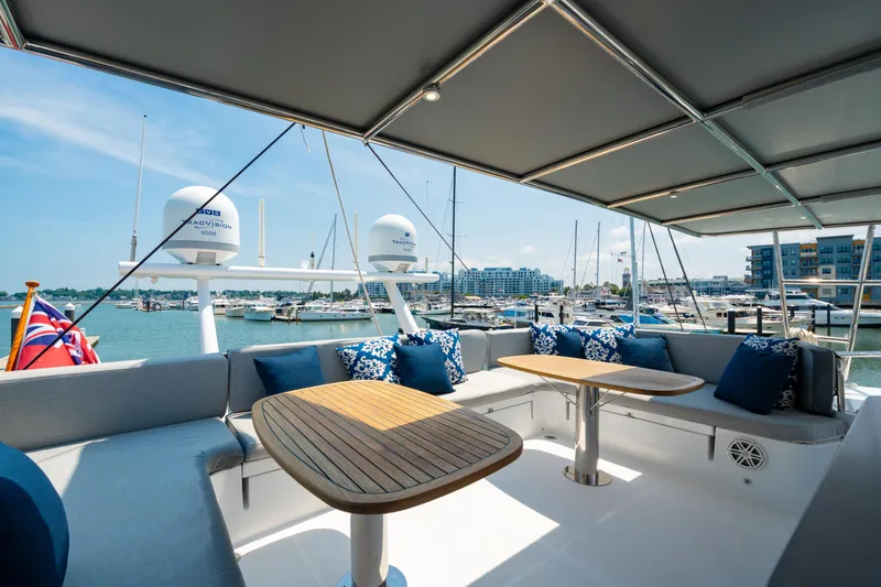 Slide: The Image of Luxurious 2008 Privilege 745 yacht deck with seating, tables, and marina view. - 19