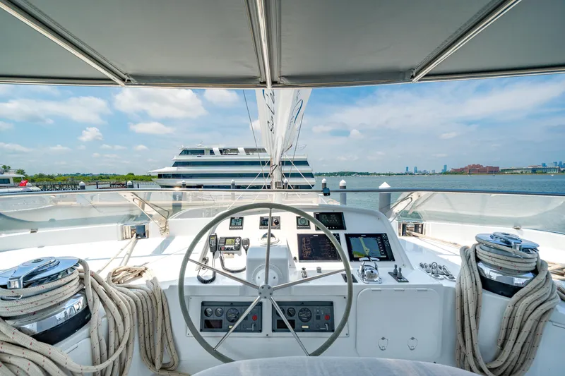 Slide: The Image of Helm of 2008 Privilege 745 yacht with navigation equipment, overlooking calm waters and distant cityscape. - 20