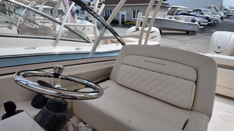 Slide: The Image of 2026 Grady-White Freedom 285 boat interior with steering wheel and cushioned seating. - 16