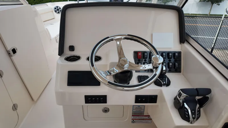Slide: The Image of 2026 Grady-White Freedom 285 boat helm with steering wheel and controls. - 17