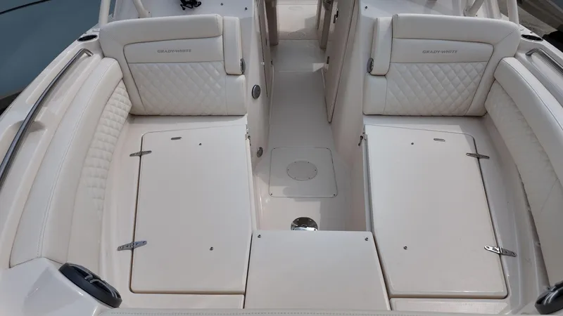 Slide: The Image of 2026 Grady-White Freedom 285 boat interior with white cushioned seating and storage compartments. - 22