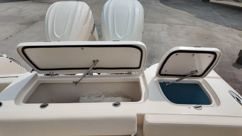 Slide: The Image of 2026 Grady-White Freedom 285 boat storage compartments with open lids, showcasing interior space. - 6