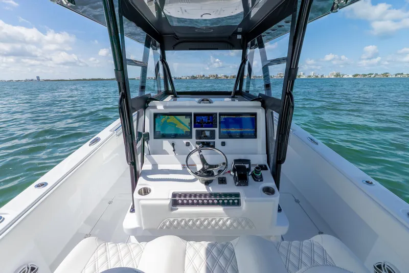 Slide: The Image of 2026 Invincible 33 Catamaran helm with navigation screens on open water. - 14