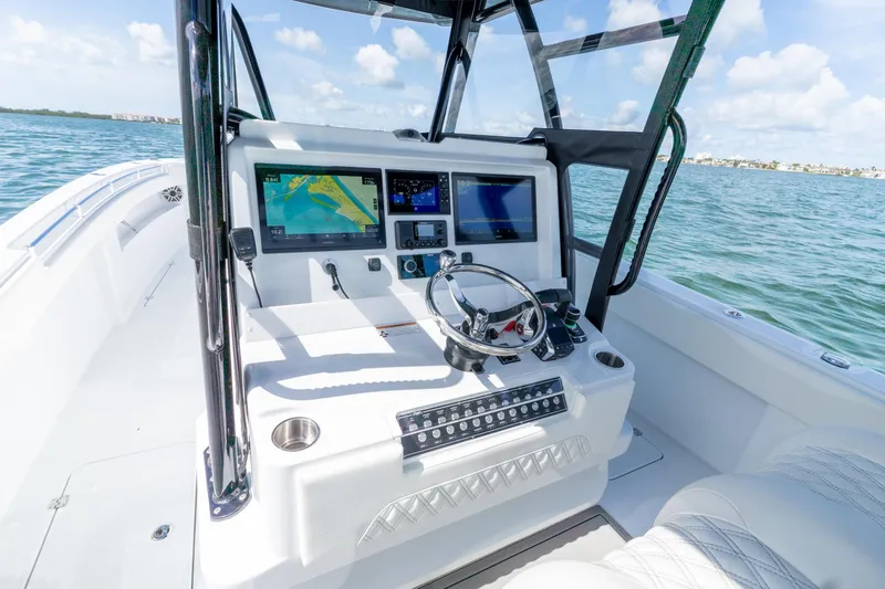 Slide: The Image of 2026 Invincible 33 Catamaran cockpit with advanced navigation screens and steering wheel on open water. - 15