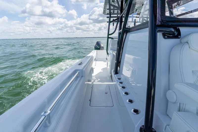 Slide: The Image of 2026 Invincible 33 Catamaran cruising on open water under a cloudy sky. - 19