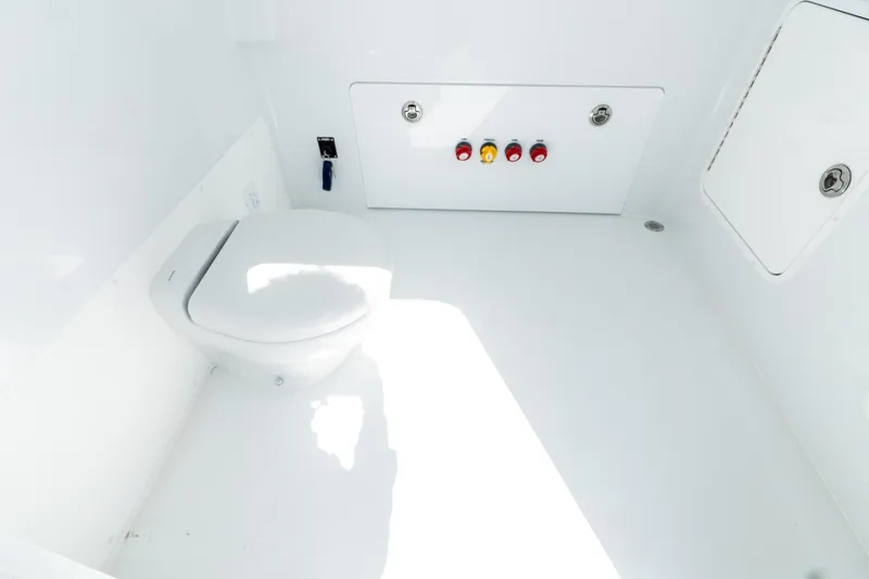 Slide: The Image of Interior of 2026 Invincible 33 Catamaran, featuring a sleek white marine toilet setup. - 25