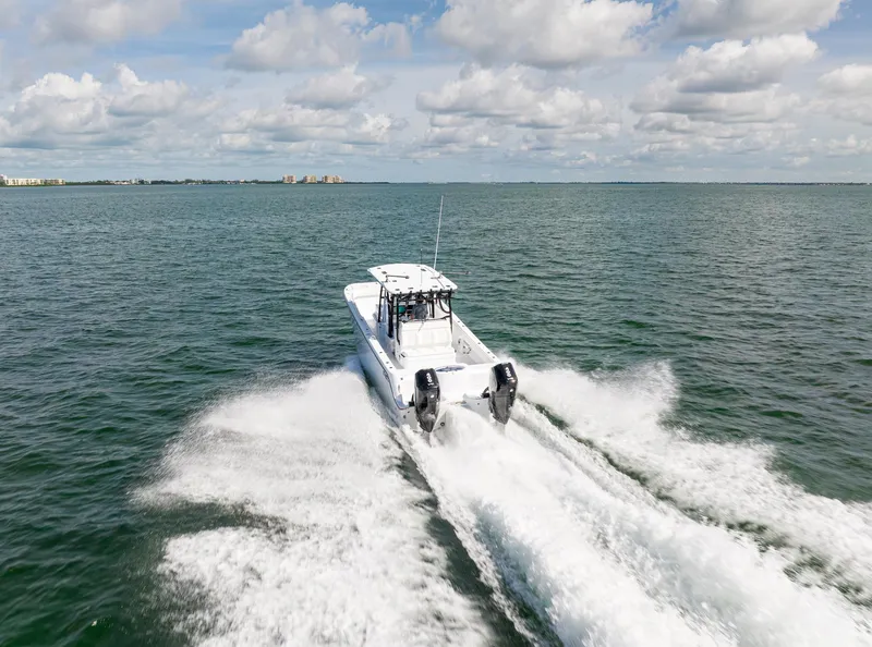 Slide: The Image of 2026 Invincible 33 Catamaran speeding on open water under a partly cloudy sky. - 3