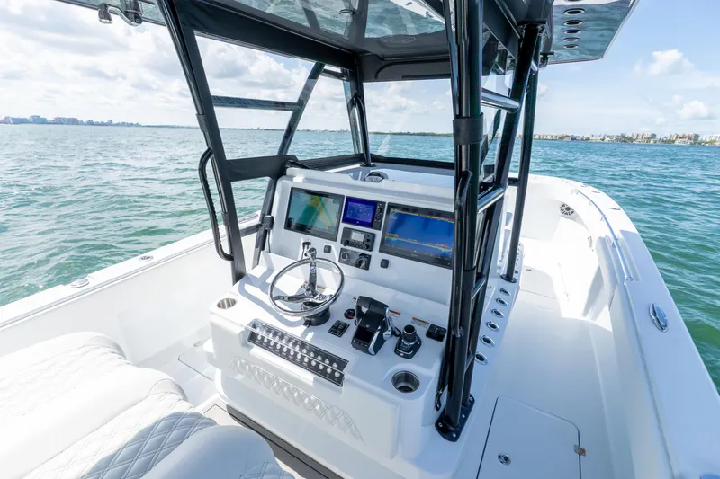 Slide: The Image of 2026 Invincible 33 Catamaran cockpit with modern navigation system on open water. - 35
