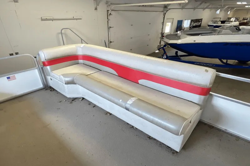 Slide: The Image of 2007 Palm Beach 220 LX boat interior with red and white seating in a garage. - 10