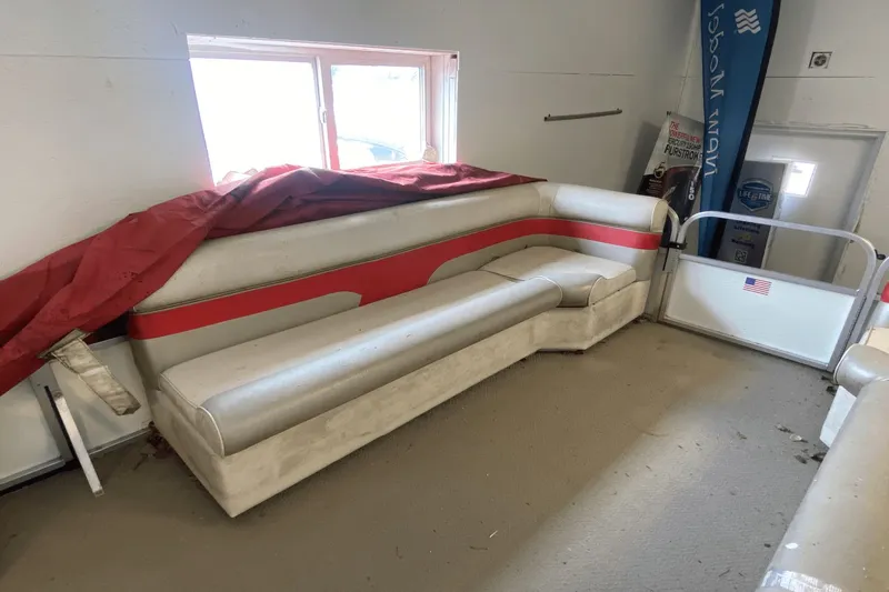 Slide: The Image of 2007 Palm Beach 220 LX boat interior with red and white seating, stored indoors. - 11