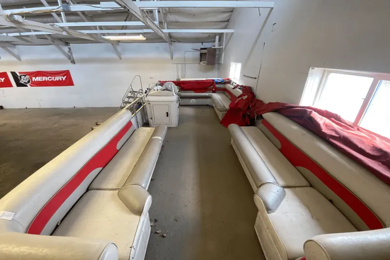 Slide: The Image of 2007 Palm Beach 220 LX boat interior with red and white seating in a garage. - 12