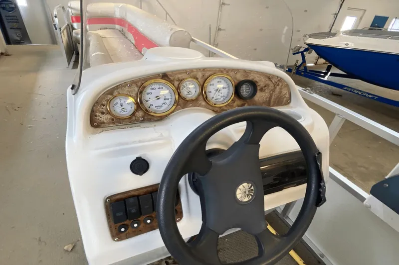 Slide: The Image of 2007 Palm Beach 220 LX boat dashboard with steering wheel and gauges in a garage. - 6