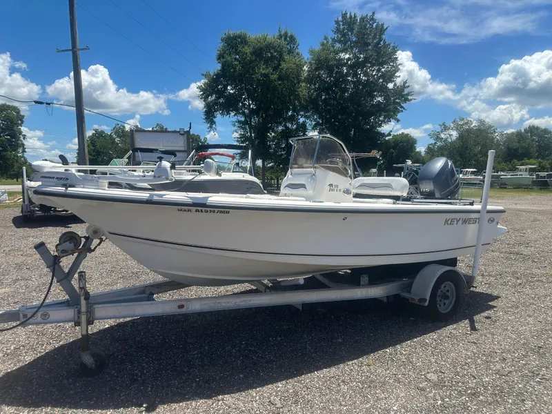 The Image of 2009 Key West 176 Bay Reef boat on trailer, parked outdoors under blue sky. - 1