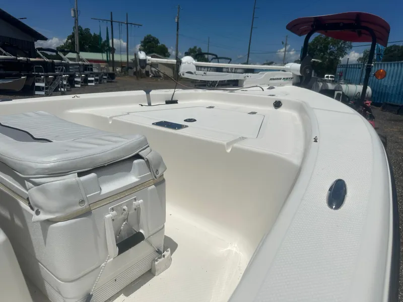 Slide: The Image of 2009 Key West 176 Bay Reef boat interior with seating and storage, parked outdoors. - 11