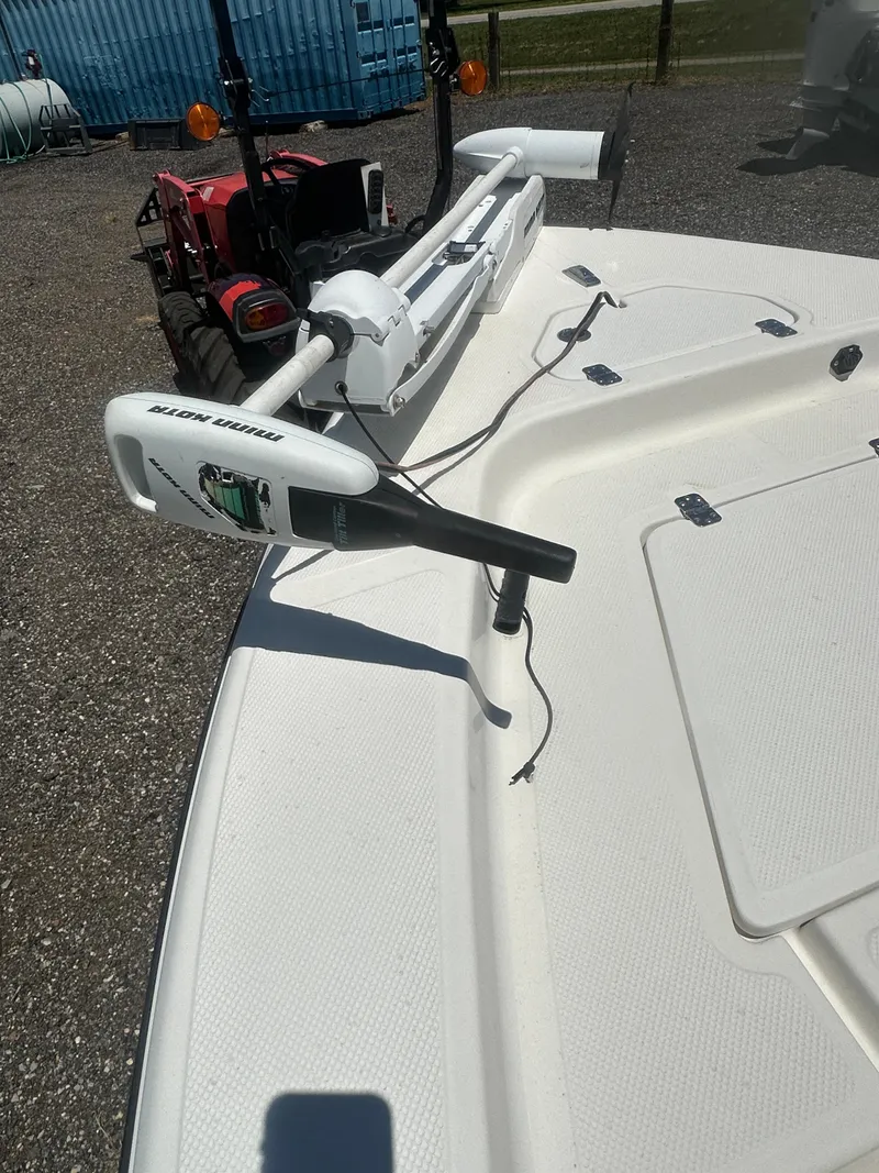 Slide: The Image of 2009 Key West 176 Bay Reef boat with trolling motor, parked near a red tractor. - 16
