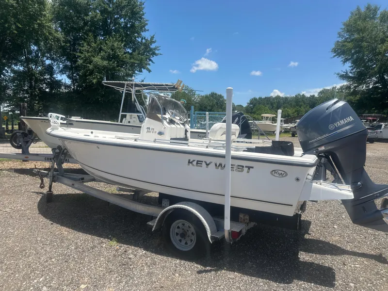 Slide: The Image of 2009 Key West 176 Bay Reef boat on trailer, parked outdoors under clear blue sky. - 19