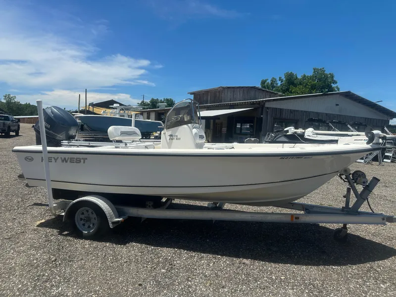 Slide: The Image of 2009 Key West 176 Bay Reef boat on trailer, parked outdoors under clear sky. - 7