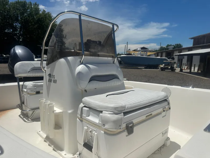 Slide: The Image of 2009 Key West 176 Bay Reef boat interior with seating and console, under clear blue sky. - 9