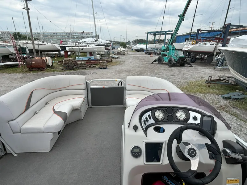 Slide: The Image of 2018 SunCatcher V16 Cruise pontoon boat interior with steering console and seating, docked at marina. - 5