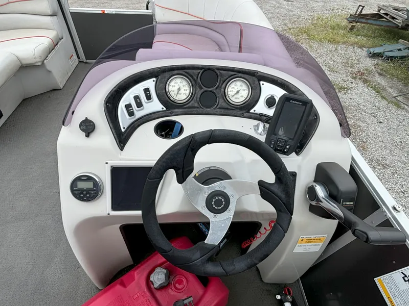 Slide: The Image of 2018 SunCatcher V16 Cruise boat dashboard with steering wheel, gauges, and navigation system. - 7