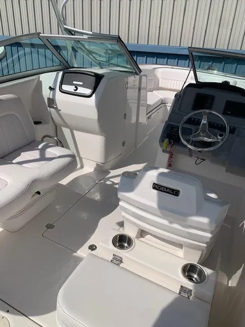 Slide: The Image of 2014 Robalo R247 Dual Console boat interior with steering wheel and seating. - 11