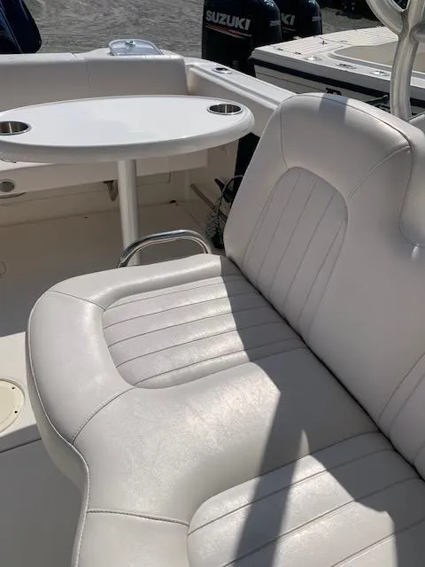 Slide: The Image of 2014 Robalo R247 Dual Console boat interior with white seating and table. - 12