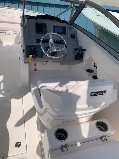 Slide: The Image of 2014 Robalo R247 Dual Console boat interior with steering wheel and dashboard. - 6