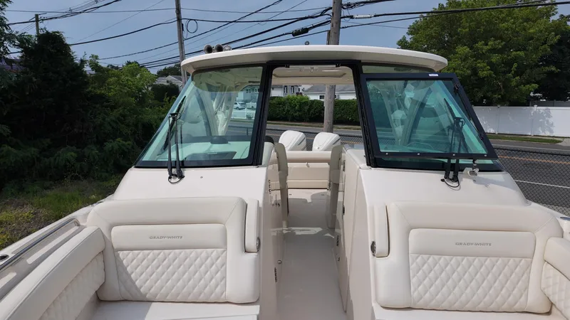 Slide: The Image of 2026 Grady-White Freedom 325 boat with luxurious seating and dual windshields, docked outdoors. - 20
