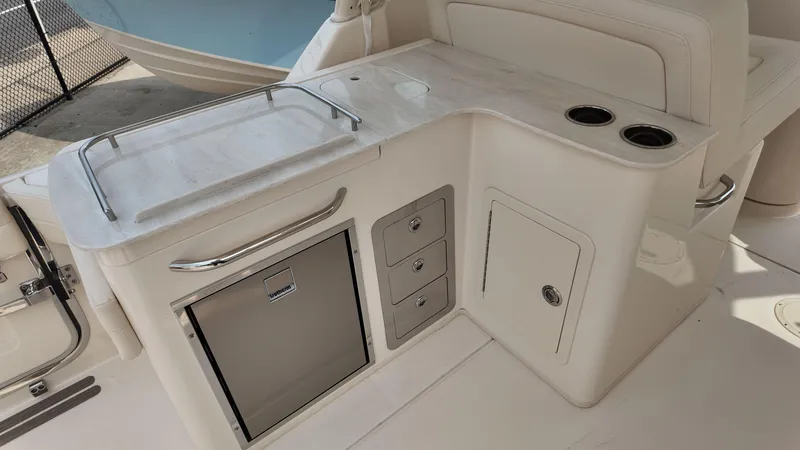 Slide: The Image of 2026 Grady-White Freedom 325 boat interior with kitchenette and storage compartments. - 9