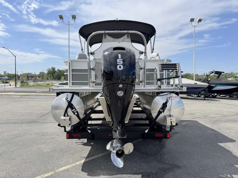 Slide: The Image of 2025 Trifecta 22TRFC LE pontoon boat with powerful outboard motor, parked outdoors. - 4